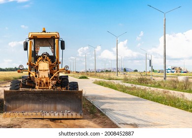Road grader - heavy equipment for road construction and earthworks. Leveling and improvement of the ground surface. Construction of roads and transport communications