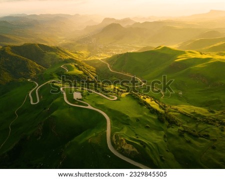 Road in the green mountains at sunset. Gumbashi Pass in North Caucasus, Russia. Beautiful summer landscape