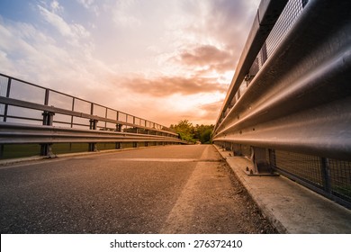 Road And Guard Rails At The Sunset