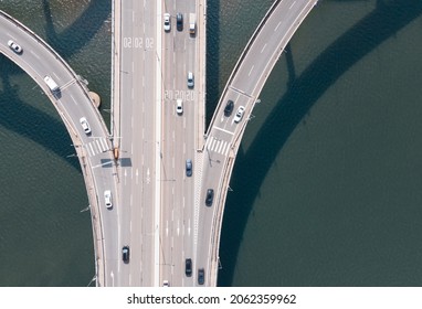 Road Junction And Bridge On River In The City, Aerial View.