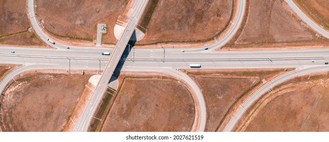 Road Junction On The Red Land Aerial Panoramic View. Highway And Half Clover Leaf Junction Part With Traffic