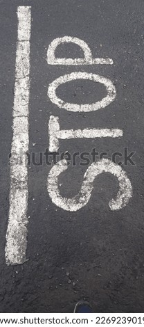 Road junction, stop word, motion blurred car in pouring rain
