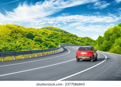 Road landscape with red car in beautiful nature. car drive on highway scenery. View of travel by car on mountain road on sunny day. summer vacation trip by car on highway by the green mountain. - Powered by Shutterstock