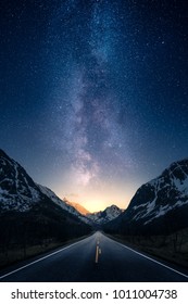 A road leading to distance in a mountain valley with milky way in the backgroung.