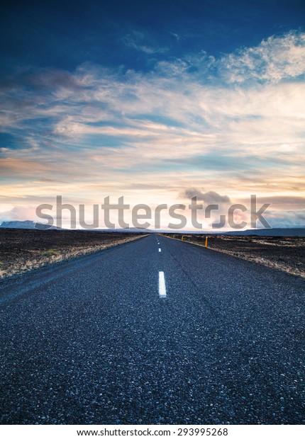 Road\
leading into the distance under a dramatic\
sky