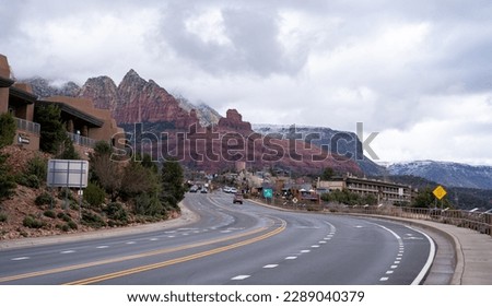 Road leading to uptown Sedona with some rock formation in the background.
