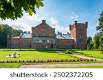 The road leads to the main entrance of the manor house  in Puikule, Latvia. Puikule Manor with its historical ambience and splendid parks is a popular tourist attraction.