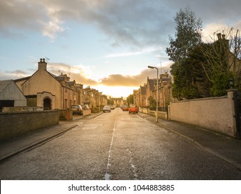 A road leads to a quiet residential neighbourhood area with traditional British style houses during sunset. Inverness, Scotland, United kingdom - Powered by Shutterstock