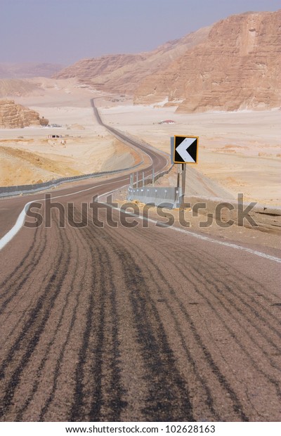 road,\
leaving a zigzag into the distance, in the\
desert