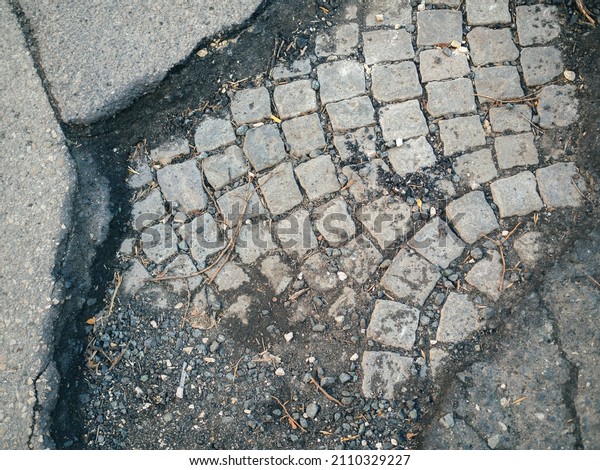 Road maintenance, poor public administration. Poor
quality asphalt pavement over paving stones. Puddles (potholes) on
the road 