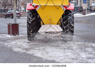 Road Maintenance, Winter Gritter Vehicle. Snow Plow On Pedestrian Street Salting And Cleaning Road. Tractor De-icing Street, Spreading Salt On Footpath. Municipal Service Clears Street During Blizzard