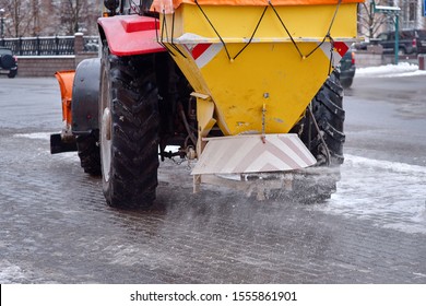 Road Maintenance, Winter Gritter Vehicle. Snow Plow On Pedestrian Street Salting And Cleaning Road. Tractor De-icing Street, Spreading Salt On Footpath. Municipal Service Clears Street During Blizzard