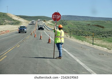 Road Maintenance Worker On Site Holding Sign