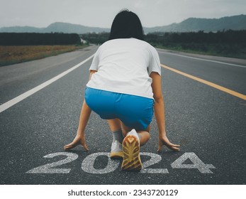 Road marked 2024 Young Asian woman preparing to run ahead New beginnings and new ideas new investments starting a new business.