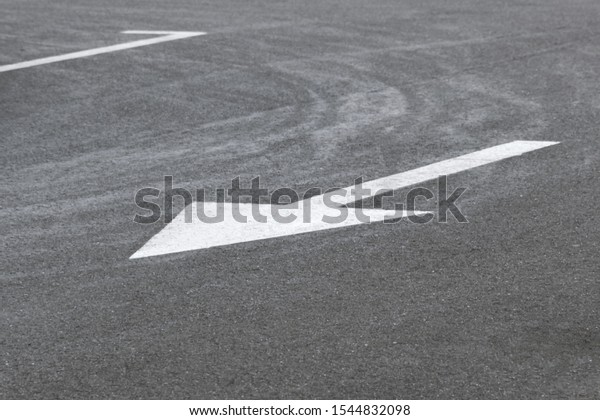 Road\
marking on asphalt with direction of\
movement