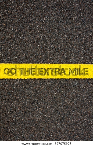 Road marking yellow paint dividing line
with words GO THE EXTRA MILE, concept
image