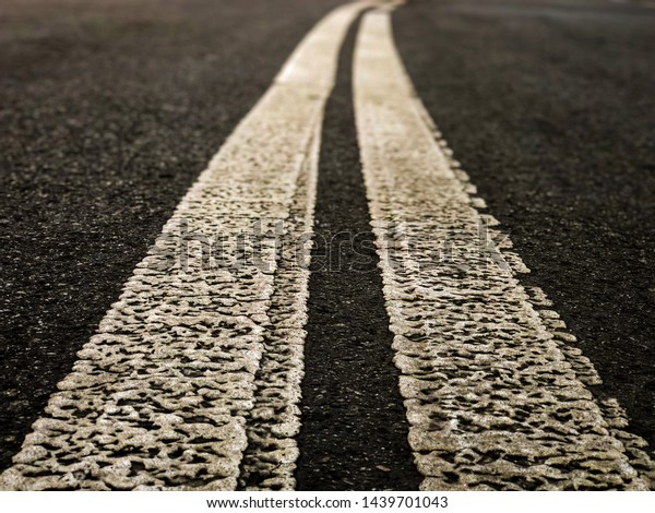The road with markings leads into the\
distance on a blurred\
background.