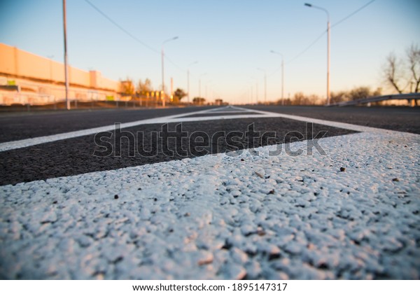 Road markings on\
asphalt on the street. White dividing line and special road marking\
symbols on black asphalt