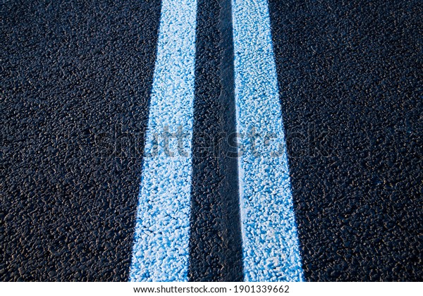Road markings on\
asphalt on the street. White dividing line and special road marking\
symbols on black asphalt