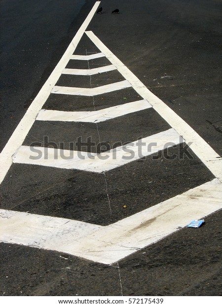 Road\
markings on asphalt. White arrow on the\
road.