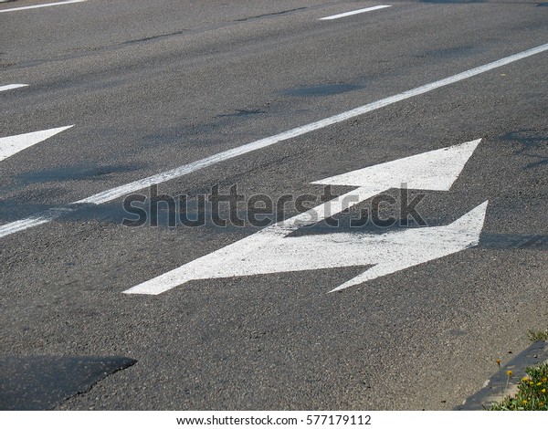 Road
markings on asphalt. White arrow on the
road.