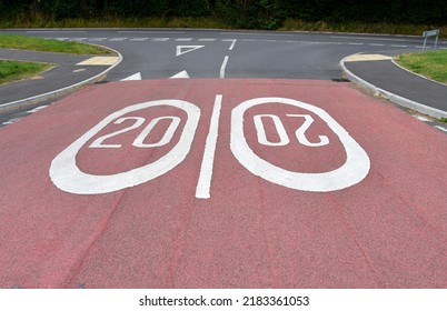 Road markings showing a 20 mph speed limit at the approach to a residential area