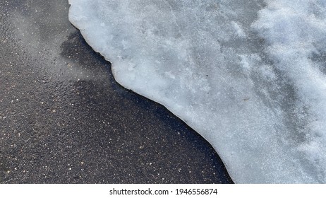 Road With Melted Snow And Ice In Early Spring. Spring Puddles, Snow Drifts, Snow, Mud And Melted Dirty Water Stream