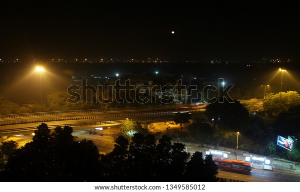 A road at midnight with full moon in central area\
of New Delhi