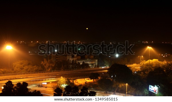 A road at midnight with full moon in central area\
of New Delhi
