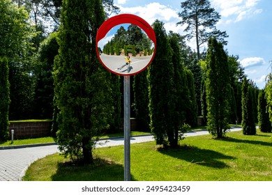 Road mirror, spherical observation at an intersection, photographer's reflection in the mirror