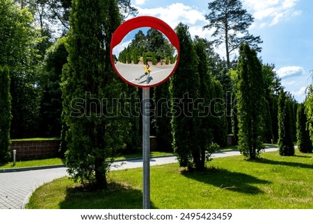 Road mirror, spherical observation at an intersection, photographer's reflection in the mirror