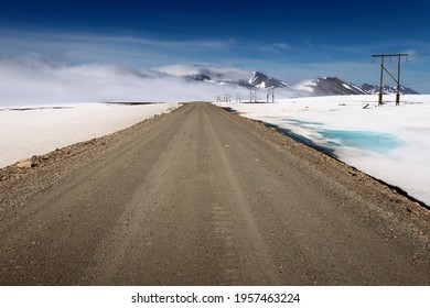Road to misty mountains among snow fields in Chukotka, Far East Russia
