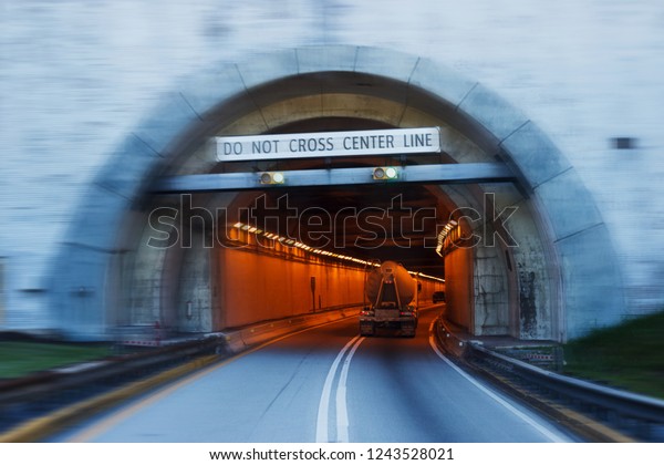 The road in the\
mountains, the entrance to the tunnel. A light in the end of a\
tunnel. The movement of\
cars.
