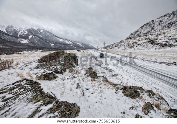 road in the\
mountains, high mountains in the winter season the land and the\
road covered with snow walking\
tourists