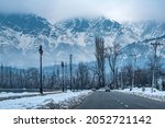 Road next to Dal Lake in winter, and the beautiful mountain range in the background in the city of Srinagar, Kashmir, India.