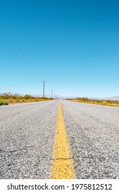 Road To Nowhere. California Desert Highway - Asphalt With Yellow Traffic Line With Blue Sky.