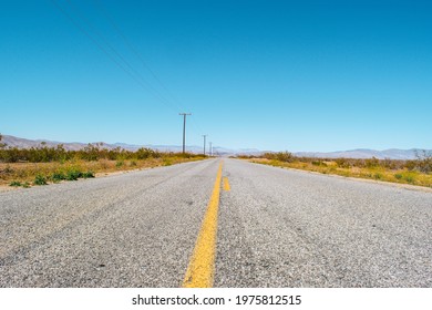 Road To Nowhere. California Desert Highway - Asphalt With Yellow Traffic Line With Blue Sky.