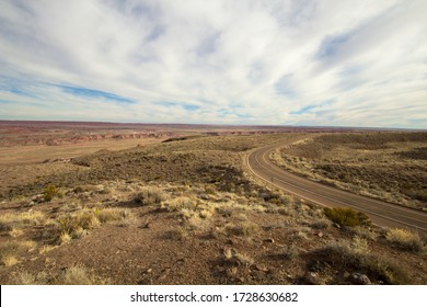 Road To Nowhere. Remote empty desert blacktop road winds through a barren landscape in the American Southwest.