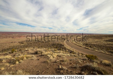 Road To Nowhere. Remote empty desert blacktop road winds through a barren landscape in the American Southwest.