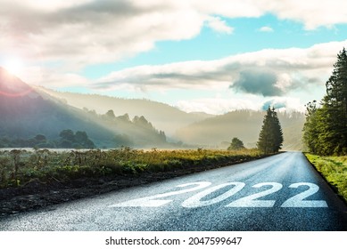 road on which is written 2022 at sunrise in the mountains ilis.beginning 2022. morning fog near the forest and mountains and road.  - Shutterstock ID 2047599647