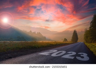 road on which is written 2023 at sunrise in the mountains .beginning of 2023 morning fog near the forest and mountains and the road. beautiful sky. concept of the road to ecology. - Shutterstock ID 2155315651
