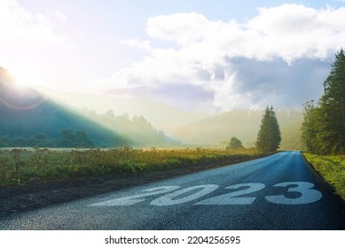road on which is written 2023 at sunrise in the mountains ilis.beginning 2023. morning fog near the forest and mountains and road. 