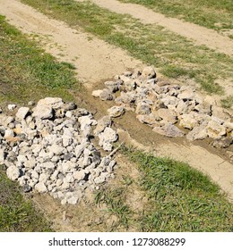 Road patching. Pits on the road are covered with stones.