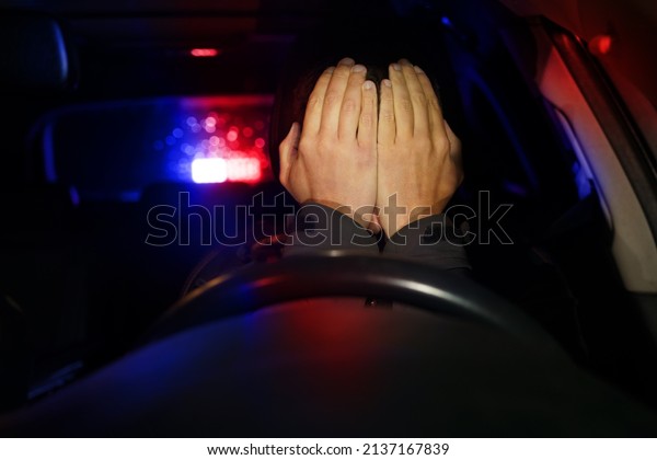 Road police with flashing lights stopped\
sad man driver. Violation of traffic\
rules