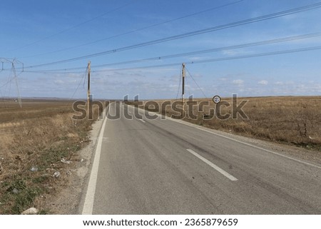 A road with power lines and a sign