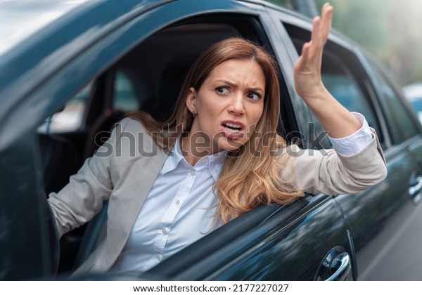 Road rage traffic jam concept. Woman is\
driving her car very\
aggressive
