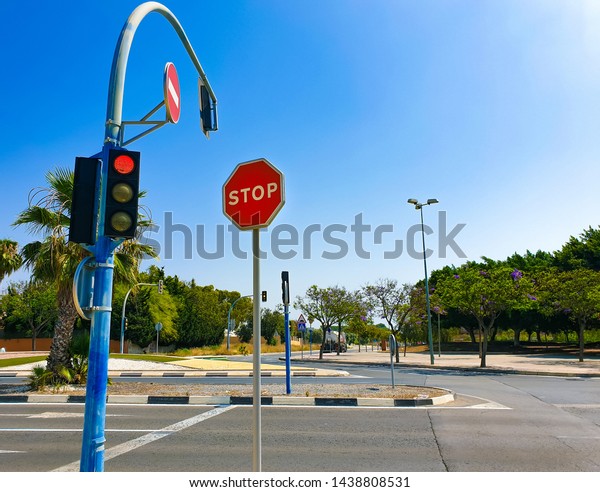 Road with red\
traffic light and stop\
sign.