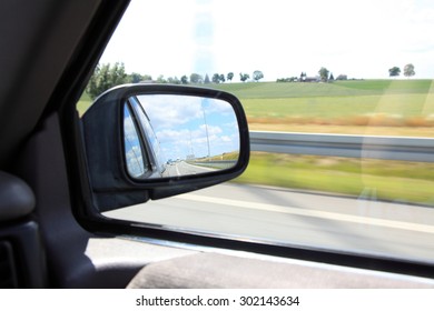 Road Reflecting In The Sideview Mirror Of A Car