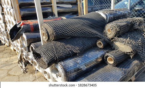 Road repair geotextiles lie in a warehouse in the yard. Geogrids, Geocomposites on rolls.