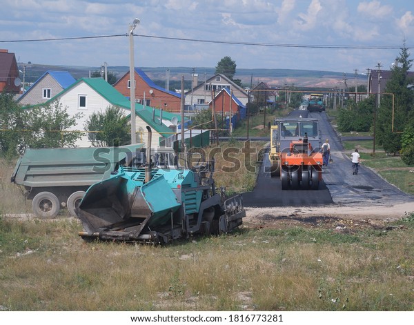 Road repairs on the street. Rinks level\
the new asphalt. Part of the image is\
blurred.